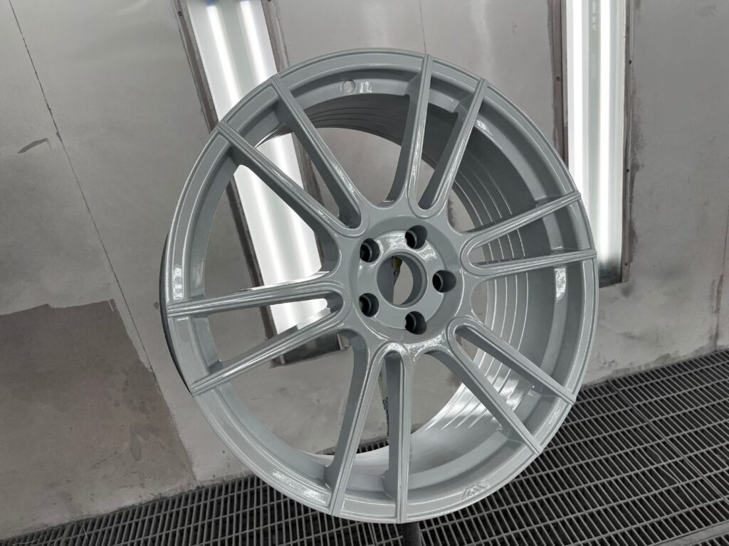Front view of an alloy wheel refinished in gloss grey